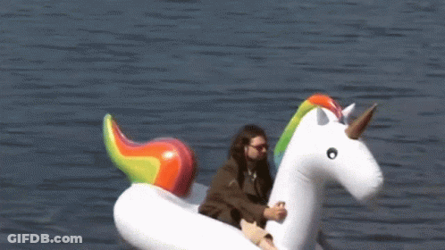 A Man Sits On An Inflatable Unicorn Floating In The Water GIF
