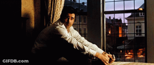 A Man Sits On The Floor In Front Of A Window GIF