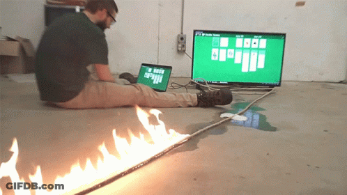 A Man Sits On The Floor Playing A Game Of Solitaire On His Laptop GIF