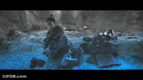 A Man Sits On The Ground In A Dark Cave GIF
