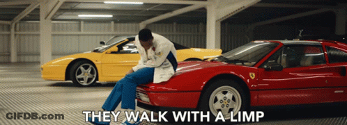 A Man Sits On The Hood Of A Red Sports Car With The Words " They Walk With A Limp " Above Him GIF