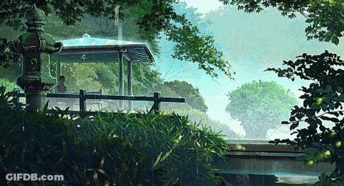 A Man Sits Under A Gazebo In A Park With A Lantern In The Foreground GIF