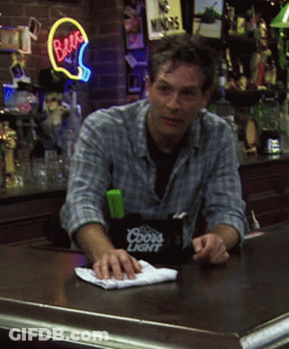 A Man Sitting At A Bar With A Coors Light Container On The Counter GIF