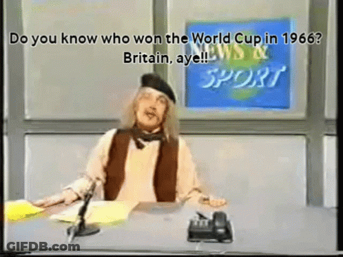 A Man Sitting At A Desk In Front Of A News And Sport Sign GIF