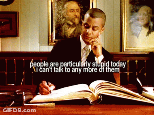 A Man Sitting At A Desk Reading A Book With The Words People Are Particularly Stupid Today GIF