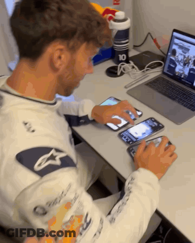 A Man Sitting At A Desk Using A Laptop And A Phone With The Number 10 On It GIF