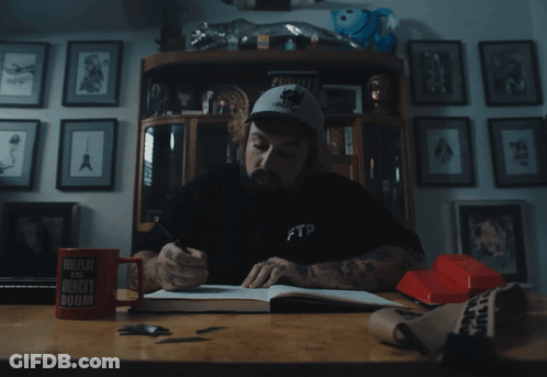 A Man Sitting At A Desk Wearing A Black Ftp Shirt GIF