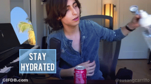 A Man Sitting At A Desk With A Can Of Coca Cola GIF