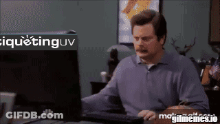 A Man Sitting At A Desk With A Computer And A Sign That Says Iquetinguv GIF