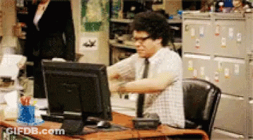 A Man Sitting At A Desk With A Computer Monitor GIF