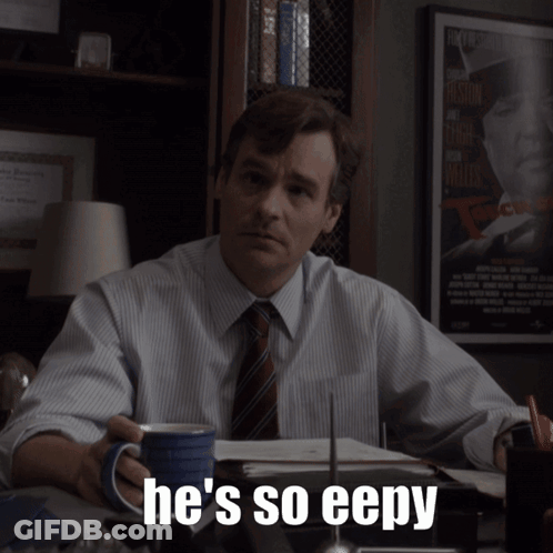 A Man Sitting At A Desk With A Cup Of Coffee And The Words He 'S So Eepy On The Bottom GIF