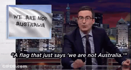 A Man Sitting At A Desk With A Flag That Says We Are Not Australia On It GIF
