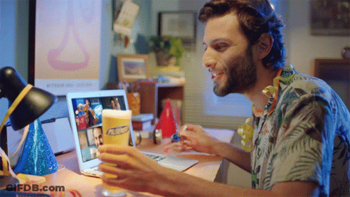 A Man Sitting At A Desk With A Laptop And A Glass Of Pabst Beer In Front Of Him GIF