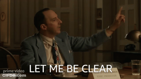 A Man Sitting At A Desk With A Sign That Says Exec Producer On It GIF