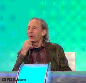 A Man Sitting At A Desk With His Hand On His Chin And A Blue Light Behind Him GIF