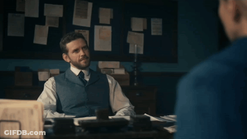 A Man Sitting At A Desk With The Words " And There We Have It " Written Below Him GIF