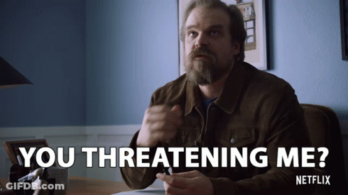 A Man Sitting At A Desk With The Words You Threatening Me GIF