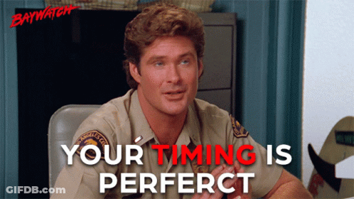 A Man Sitting At A Desk With The Words Your Timing Is Perfect GIF