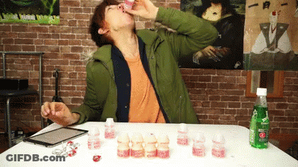 A Man Sitting At A Table Drinking From A Bottle That Says Sprite On It GIF