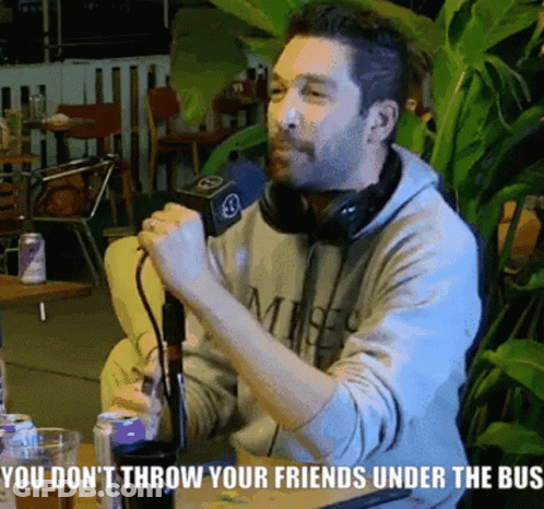 A Man Sitting At A Table Talking Into A Microphone With The Words You Do N't Throw Your Friends Under GIF