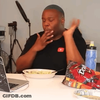 A Man Sitting At A Table With A Bag Of Doritos Next To Him GIF
