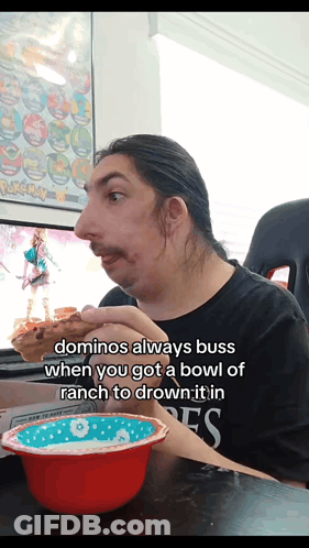 A Man Sitting At A Table With A Bowl Of Ranch And A Bowl Of Domino 'S GIF