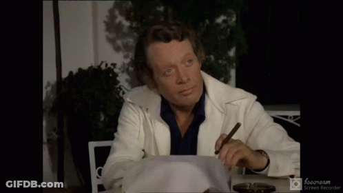 A Man Sitting At A Table With A Cigar And The Words Et Alors Written Below Him GIF