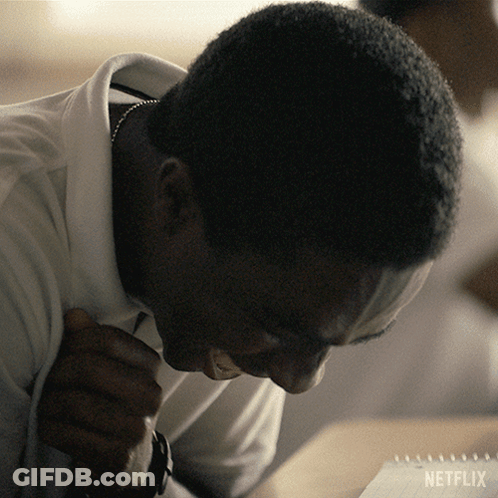 A Man Sitting At A Table With A Netflix Logo On The Bottom Right GIF