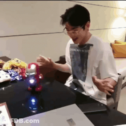A Man Sitting At A Table With A Shirt That Says Oepream 18 2007 On It GIF