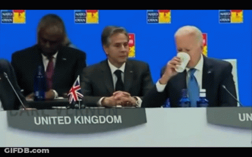 Man Sitting At Table With United Kingdom Sign GIF