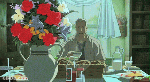 A Man Sitting At A Table With A Vase Of Flowers And A Bottle Of Ketchup GIF