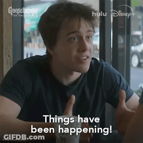 A Man Sitting At A Table With His Hands Out And The Words Things Have Been Happening Above Him GIF