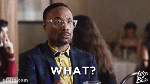 A Man Sitting At A Table With The Word What Written On His Face GIF