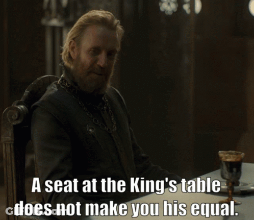 A Man Sitting At A Table With The Words A Seat At The King 'S Table Does Not Make You GIF
