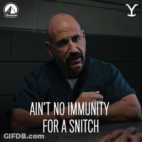 A Man Sitting At A Table With The Words " Ain 'T No Immunity For A Snitch " Below Him GIF