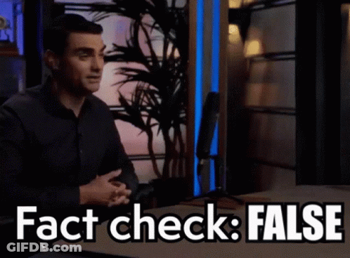 A Man Sitting At A Table With The Words " Fact Check False " Written On It GIF