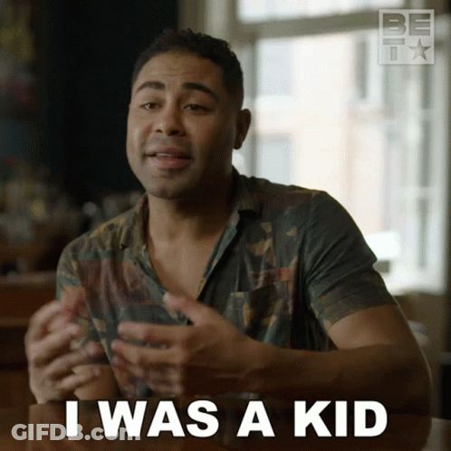A Man Sitting At A Table With The Words I Was A Kid In Front Of Him GIF
