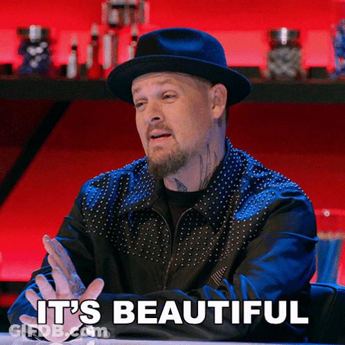 A Man Sitting At A Table With The Words It 'S Beautiful Above Him GIF