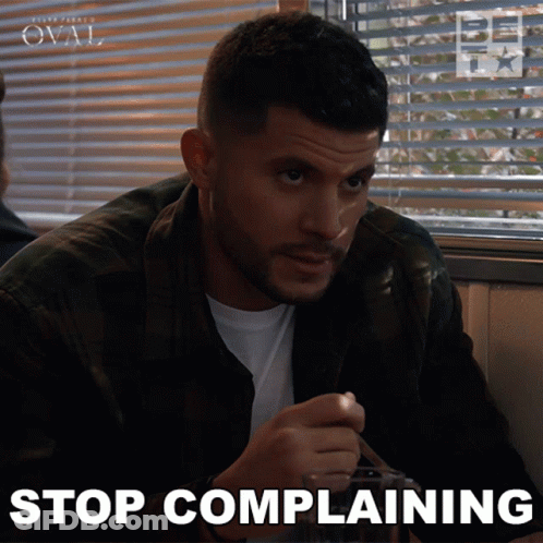 A Man Sitting At A Table With The Words Stop Complaining On The Bottom Right GIF