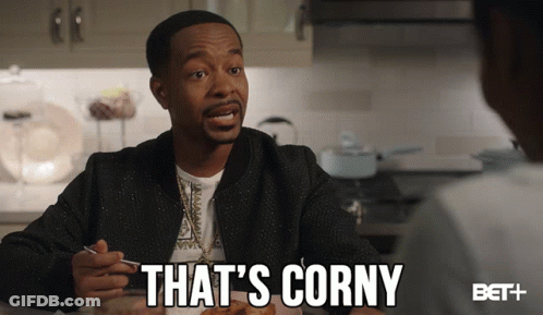 A Man Sitting At A Table With The Words That 'S Corny Written Below Him GIF