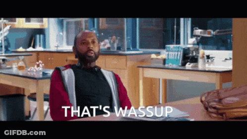 A Man Sitting At A Table With The Words That 'S Wassup Written On The Bottom GIF