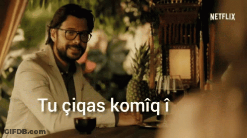 A Man Sitting At A Table With The Words Tu Ciqas Komiq I Above Him GIF