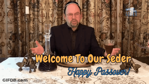 A Man Sitting At A Table With The Words Welcome To Our Seder Happy Passover On The Bottom GIF