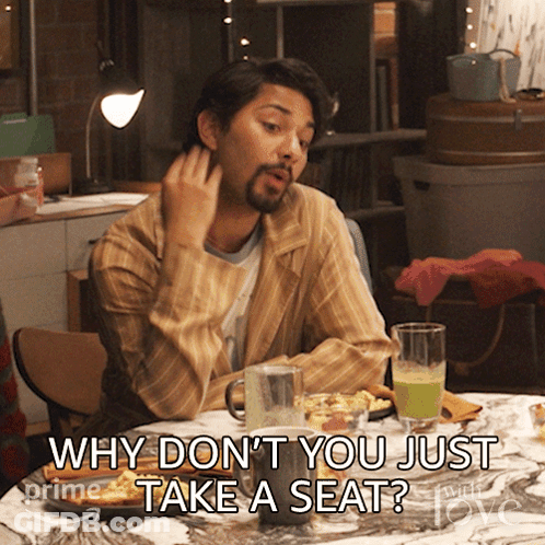 A Man Sitting At A Table With The Words Why Don 'T You Just Take A Seat GIF
