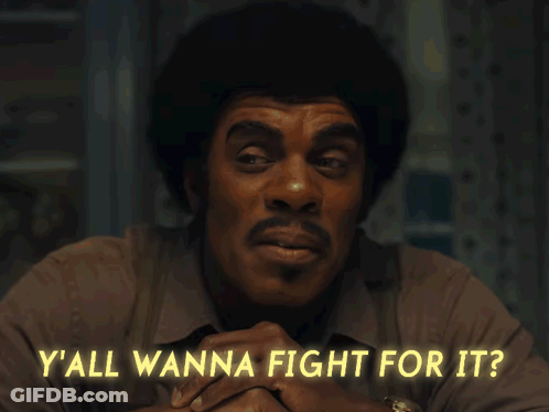 A Man Sitting At A Table With The Words Y'all Wanna Fight For It GIF