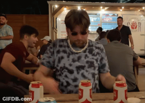 A Man Sitting At A Table With Three Cans Of Lone Star Beer On It GIF