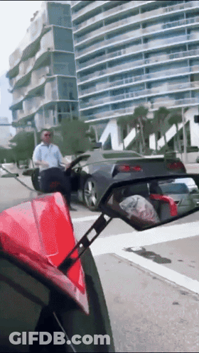 A Man Sitting In A Car Looking At Another Car In A Rear View Mirror GIF