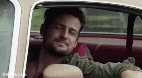 A Man Sitting In A Car With His Eyes Closed Smiling GIF