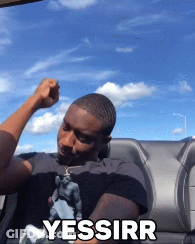 A Man Sitting In A Car With His Fist In The Air And The Word Yessirr Written On The Back GIF