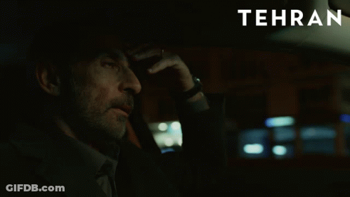A Man Sitting In A Car With Tehran Written On The Bottom GIF